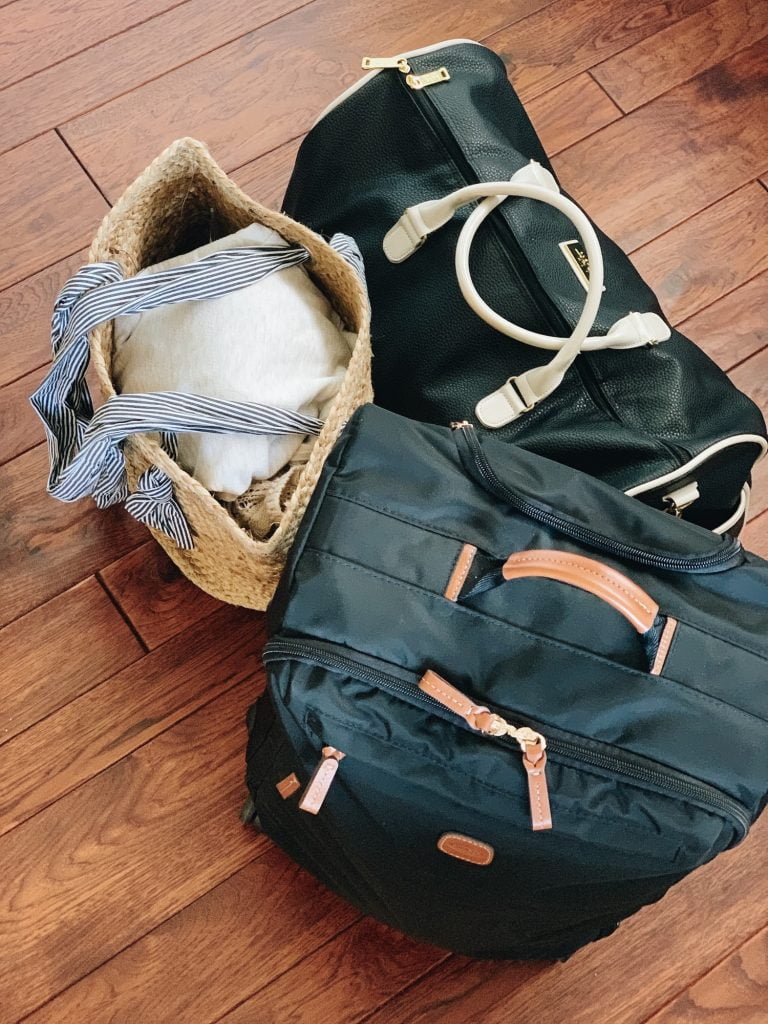 Three bags sitting on a wood floor are packed and ready to travel for a vacation
